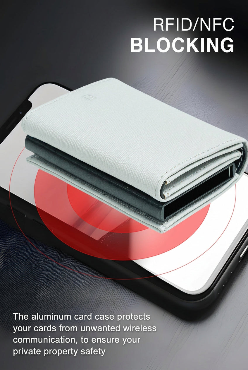 Light grey wallet stacked on a smartphone over a dark desk, with a red signal graphic showing wireless scanning being blocked.